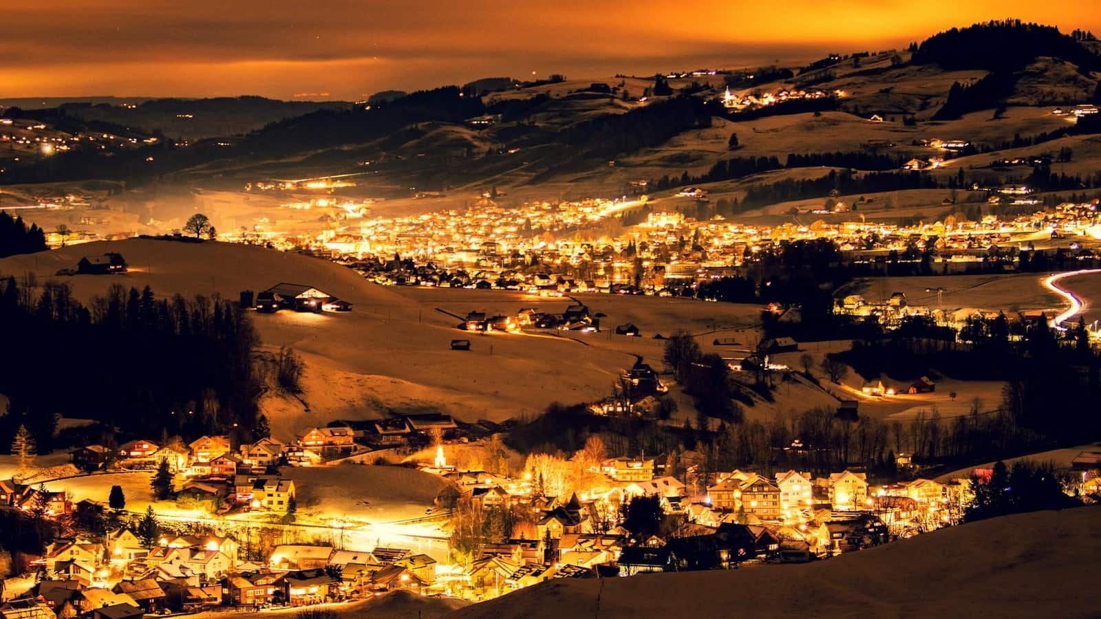 Winterliche Abendstimmung über Appenzell Innerrhoden mit leuchtenden Häusern und Hügeln
