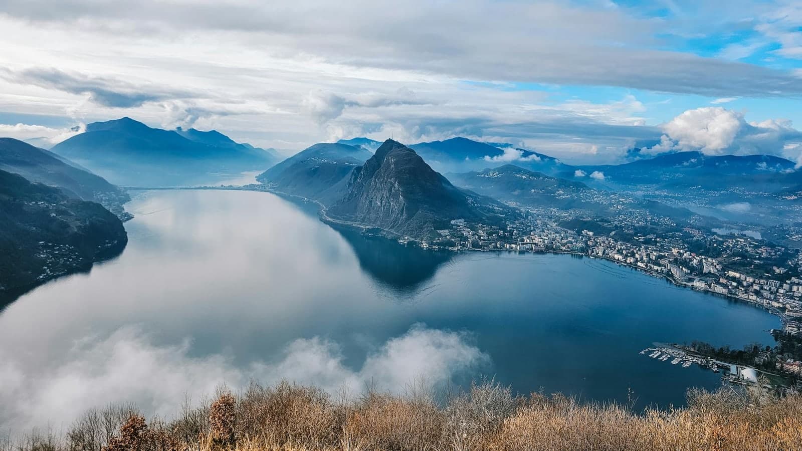 Luftblick auf den Luganersee mit Bergen und Stadt