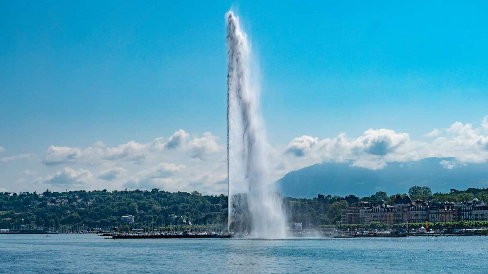 Geneva water fountain with mountains behind it